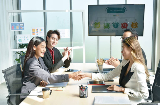 Ασιάτισσες επιχειρηματίες σφίγγουν το χέρι μαζί μετά τη συνάντηση με επιτυχία και να κερδίσει συμφωνία στο γραφείο - Φωτογραφία, εικόνα