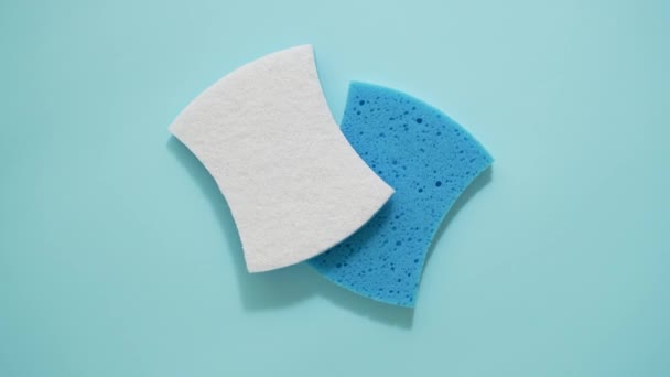 Cleaning or dishwashing sponges isolated on blue background. Top view, flat lay - Materiaali, video