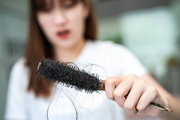 Asian woman have problem with long hair loss attach to comb brush. - Fotografie, Obrázek