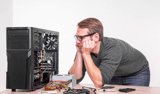 Een specialist repareert een computer. Reparatie, assemblage en restauratie van personal computers. - Foto, afbeelding