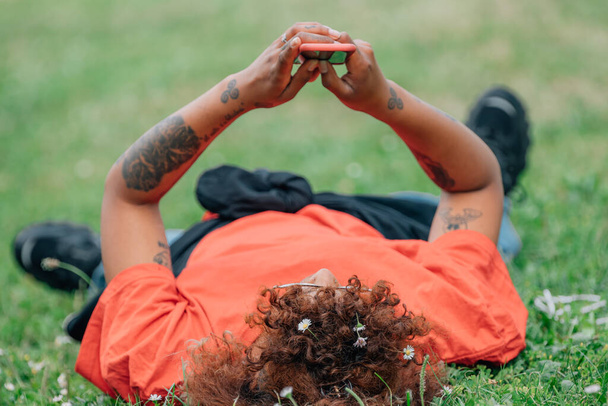 dziewczyna leżąca na trawie z telefonu komórkowego - Zdjęcie, obraz