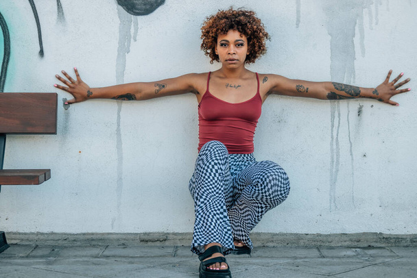 black latin african american girl in the street posing with open arms with tattoos - Foto, Imagen