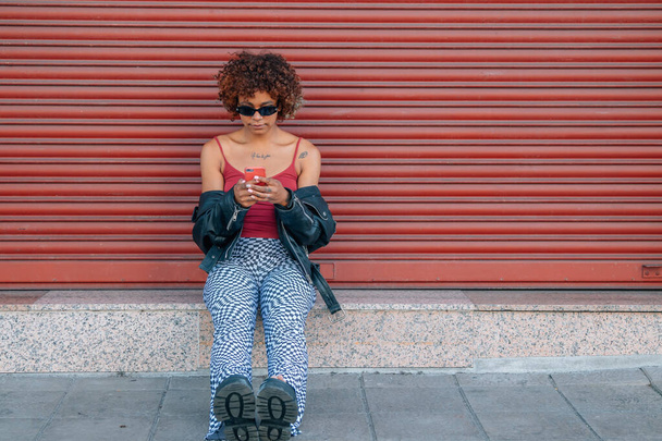 estilo urbano menina latina preta com telefone celular na rua - Foto, Imagem
