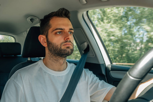 young man behind the wheel of the car driving - Valokuva, kuva