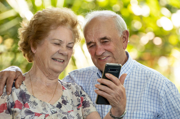 щасливі бабусі і дідусі або старша пара з мобільним телефоном
 - Фото, зображення