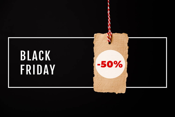 Black Friday, craft vintage price tag with minus 50 percent discount sticker isolated on black background. Black Friday sale, discount concept - Photo, Image