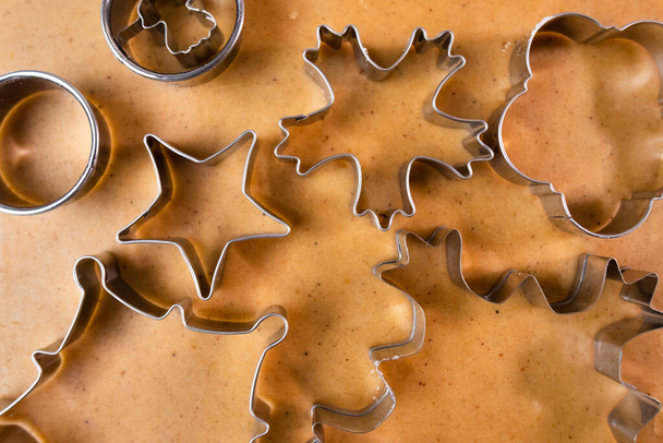 Cutting out cookies with metal mold from the shortcrust pastry. A metal forms in the form of snowflakes for making gingerbread for Christmas. - Foto, immagini