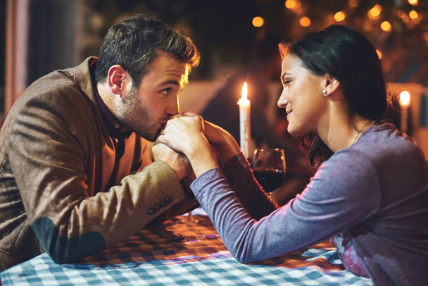 Making sure she feels special. an affectionate young couple having a romantic dinner in a restaurant - Photo, Image
