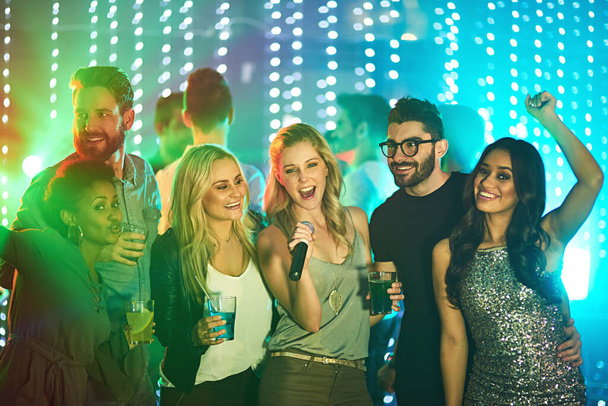 This one goes out to my friends. a group of friends singing karaoke at a party - Photo, Image