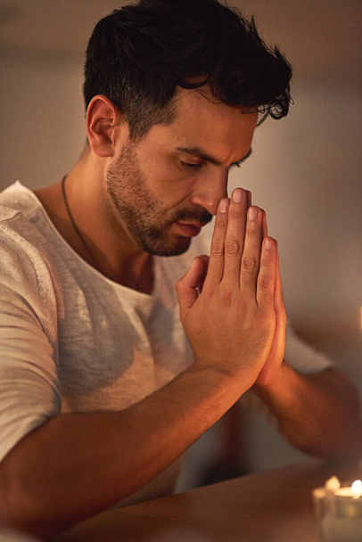 He knows where his strength comes from. a young man holding his hands together in prayer - Foto, immagini