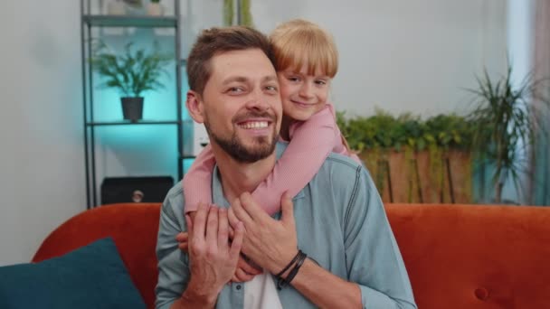 Pretty smiling cute child kid daughter embrace dad, look at camera. Happy beautiful family young adult single father foster nanny parent and toddler girl hug enjoy sweet tender love. Close-up portrait - Záběry, video