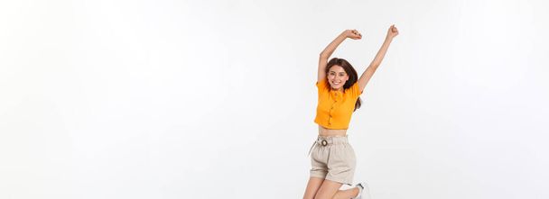 Cooles Hipster-Porträt eines jungen, stylischen Teenie-Mädchens, das die Hände in die Höhe hält, positive Stimmung und Emotionen zeigt, allein reist. isoliert über grauem Hintergrund. - Foto, Bild