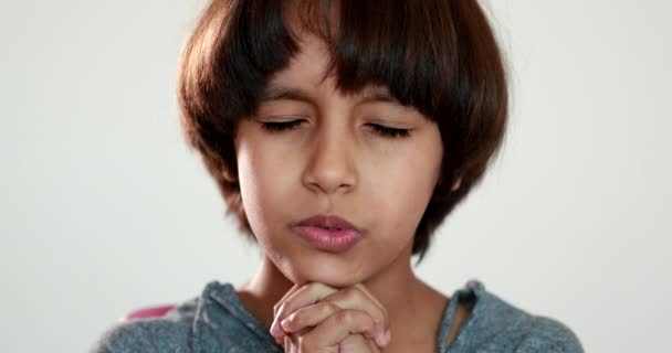 Ragazzo di razza mista che dà gratitudine, bambino che prega mani tenute insieme con gli occhi chiusi - Filmati, video