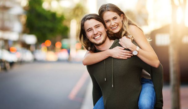 Its all fun and games when theyre together. Portrait of a happy young couple enjoying a piggyback ride in the city - Foto, immagini