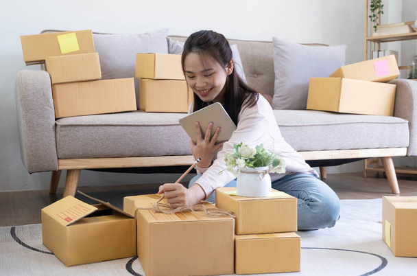 Kisvállalkozások indítása KKV-tulajdonosok női vállalkozók ellenőrizze az online megrendelések, hogy felkészüljenek a dobozok csomagolására, eladni az ügyfeleknek, sme üzleti ötletek online - Fotó, kép
