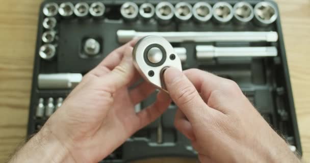 Demonstration of the work of the ratchet keys from the first person. The man switches the mode to unscrew and tighten on the socket wrench. High quality 4k footage - Felvétel, videó