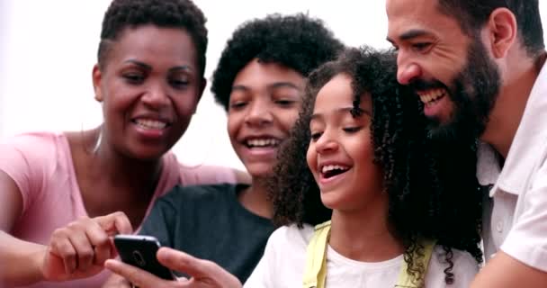 Happy multiracial family laughing and smiling together looking at phone. Real life parents and kids laugh and smile - Metraje, vídeo