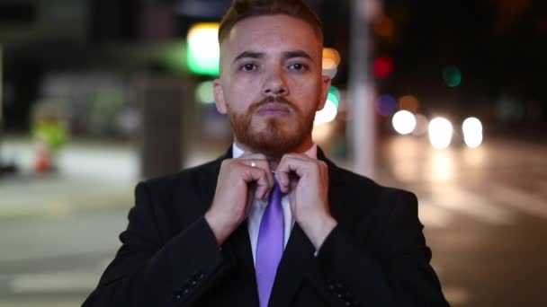 Портрет красивого бізнесмена, що регулює краватку з міським містом на задньому плані вночі
 - Кадри, відео