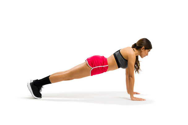 Γυμναστική νεαρή γυναίκα σε σανίδα θέτουν άσκηση με cross training κατά τη διάρκεια της υγιούς προπόνηση  - Φωτογραφία, εικόνα