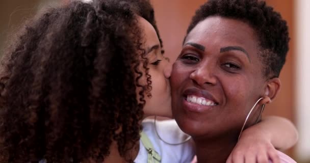 Afrikkalainen äiti ja tytär yhdessä. Pieni tyttö lapsi suudella äiti poskelle, rakkaus ja kiintymys - Materiaali, video