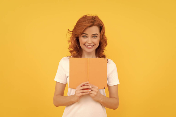 glad student on yellow background. girl study with book. private teacher holding planner. book lover. back to school. education and knowledge. woman reader reading. - Photo, Image