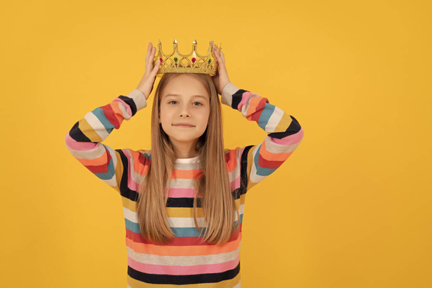 samolubne nastolatek dziecko w królowej korony na żółtym tle. - Zdjęcie, obraz