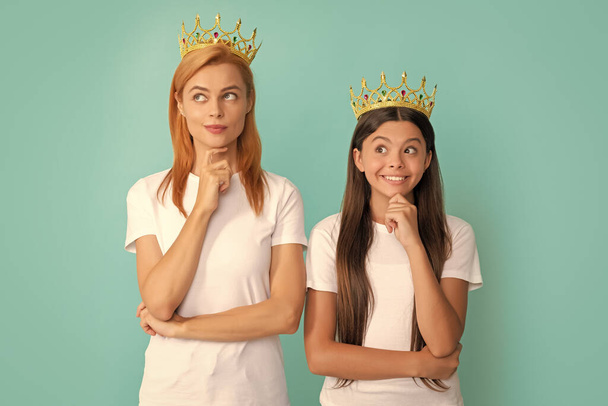 Being in doubt. Selfish mother and daughter child with pensive smile. Thoughtful woman and girl wear crowns. Beauty queen and princess think about success. Selfish and egoistic. - Photo, Image