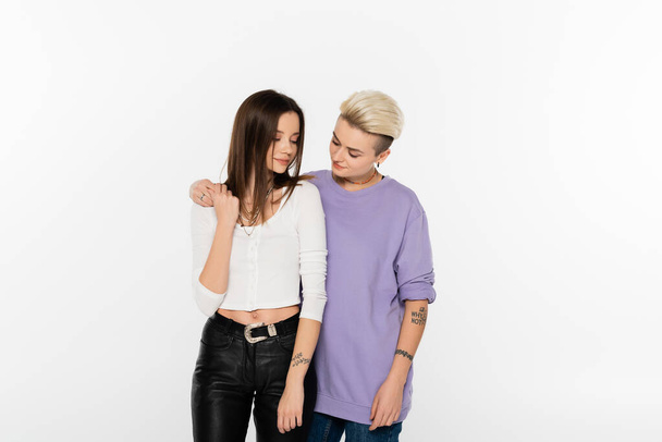 young and stylish lesbian partners holding hands isolated on grey - Foto, Imagen