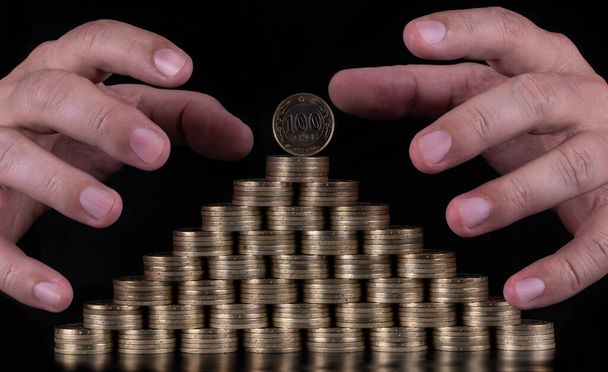 100 Kazachstani tenge munten gestapeld in de vorm van een piramide - Foto, afbeelding