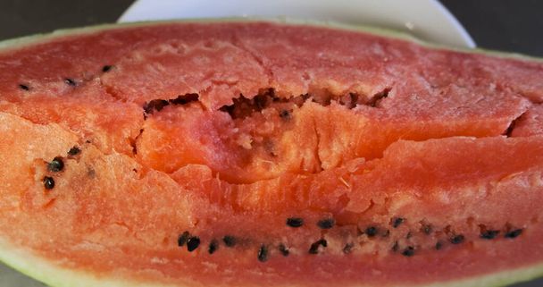 Huge piece of red watermelon lies on a plate. Panorama above the plate, top view, close-up. High quality 4k footage - Foto, immagini