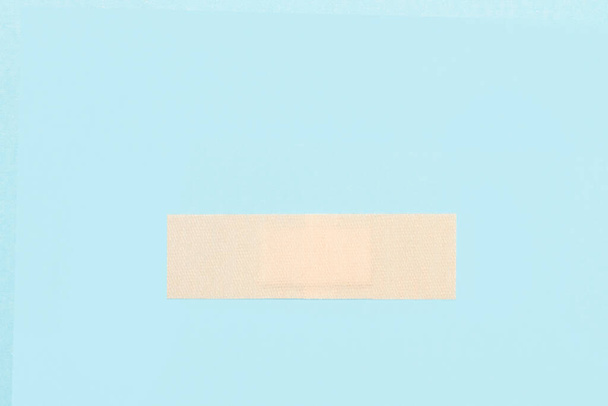 An adhesive bandage on a light blue background with copy space - Foto, imagen