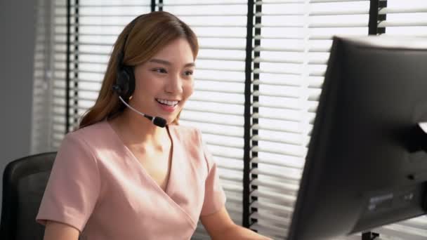Competent female operator working on computer and while talking with clients. Concept relevant to both call centers and customer service offices. - Metraje, vídeo