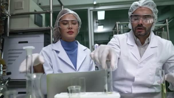 Two scientist in professional uniform working in curative laboratory for chemical and biomedical experiment - Záběry, video