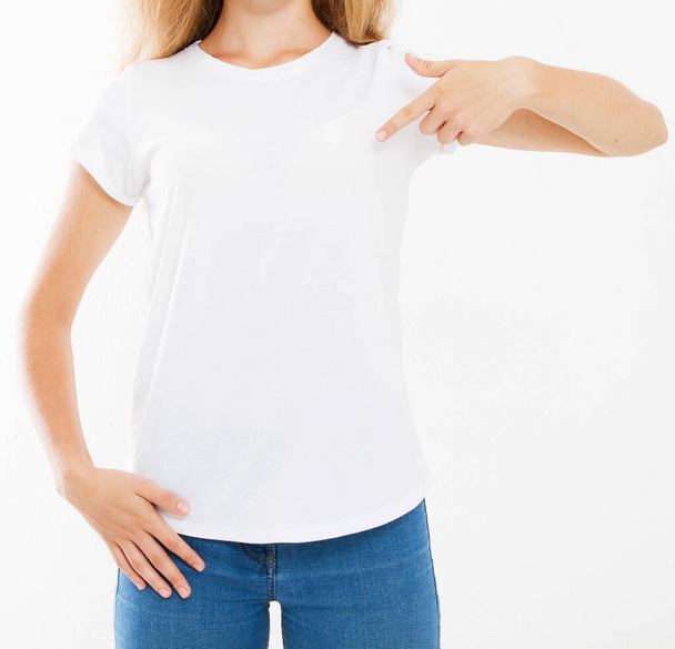 Attraktive kaukasische Frau zeigt mit den Fingern auf ihr leeres weißes T-Shirt auf weißem Hintergrund - Foto, Bild