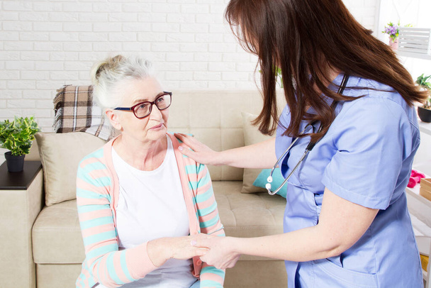 Nahaufnahme einer älteren Frau, die mit Physiotherapeutin trainiert, einer älteren Frau mit Krankenschwester zu Hause - Foto, Bild