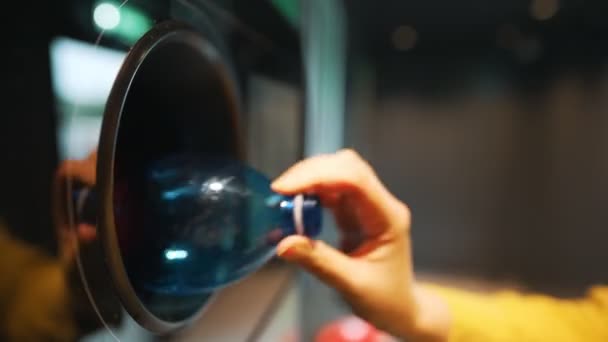 Vrouw doet fles in automatische fles recycling machine. Omgekeerde verkooprecyclingmachine. - Video