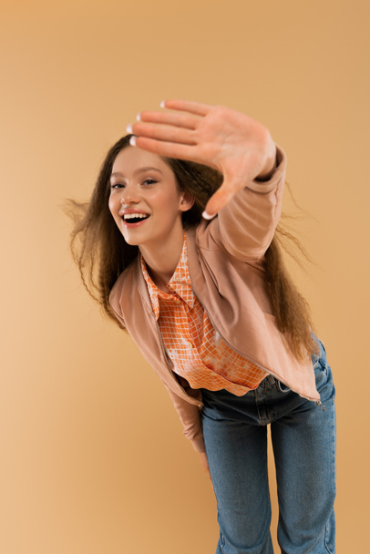 excited teenage girl in autumnal and casual clothes showing stop gesture isolated on beige - Foto, Bild