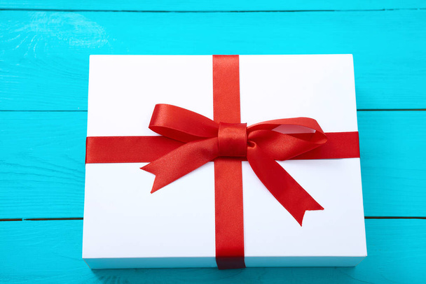 Μοντέρνο κουτί δώρου σε μπλε ξύλινο φόντο με χώρο αντίγραφο. Επιλεκτική εστίαση και κορυφαία προβολή. - Φωτογραφία, εικόνα