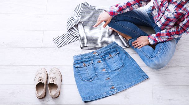 Fashion clothes and teenager sitting on white wooden floor. Top view - Foto, imagen