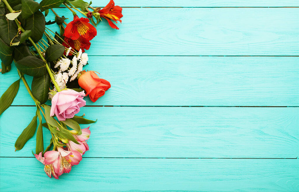 Frame van bloemen op blauwe houten ondergrond. Valentijnsdag. Bovenaanzicht en kopieerruimte. - Foto, afbeelding