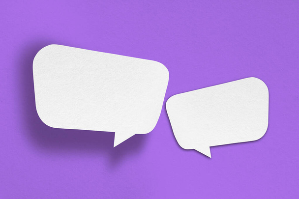 white paper with speech bubbles isolated on purple background communication bubbles design - Foto, immagini