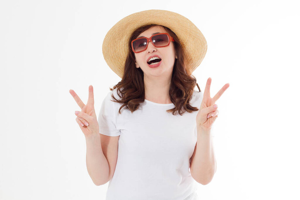 Yazlık şapkalı, güneş gözlüklü ve beyaz tişörtlü mutlu ve heyecanlı bir kadın. Büyük indirimli tatil. Eğlenceli bir yaz tatili. Boşluğu kopyala, tişörtte boş yer. - Fotoğraf, Görsel