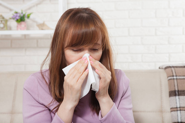 Beteg nő, aki otthon ül magas lázzal. Megfázás, influenza, láz és migrén, tüsszentés. Másold a helyet. Orrfolyás - Fotó, kép