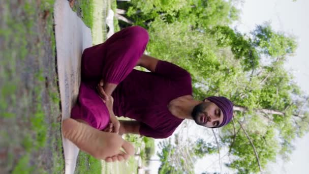 An arabian man running yoga class - teaches how to properly sit in the lotus position. Mid shot - Video