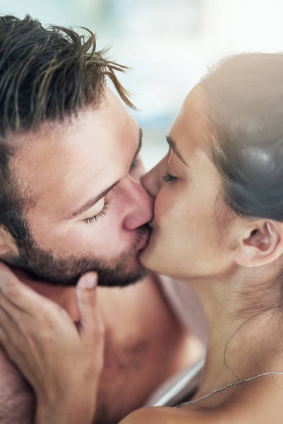 Lets get lost in each other. a loving young couple sharing an intimate kiss at home - Foto, Bild