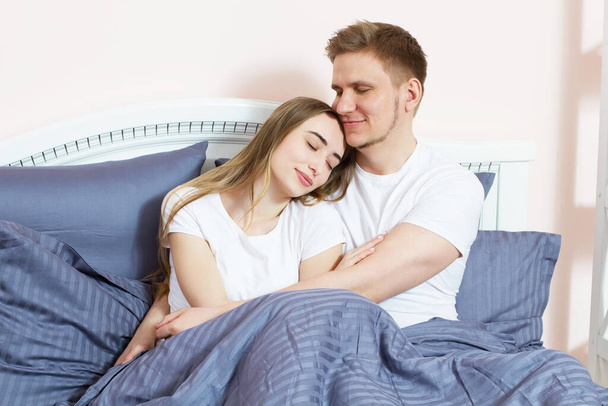 Молодий чоловік і жінка в ліжку вранці
 - Фото, зображення