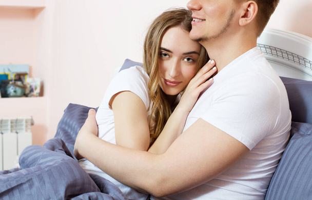Large portrait : Young lovely couple on bed, morning bedroom. Happy loving couple in the bedroom in morning Copy space . Family couple people concept. - Photo, Image