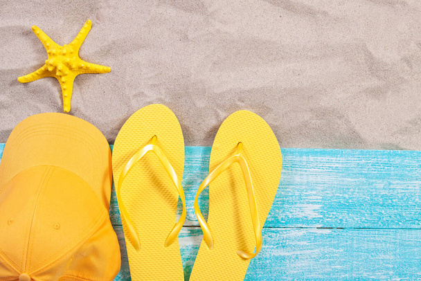 Sand copy space. Sand background top view.Beach towel, beach slippers, yellow bluzer and starfish - Fotoğraf, Görsel
