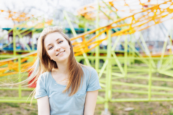 Happy young Gen Z woman in an amusement park, smiling. Copy space. Summer time - Foto, imagen