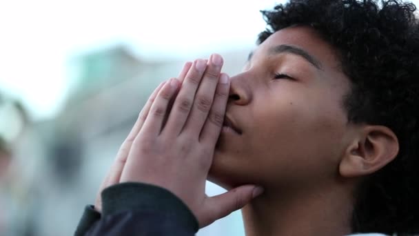 Духовный юноша молится. ребенок, открывающий глаза на небо с надеждой и верой - Кадры, видео